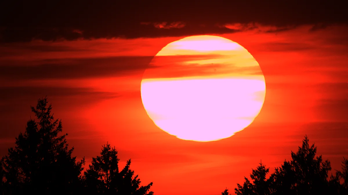 Coucher de soleil, les taches solaires sont visibles à travers les nuages !